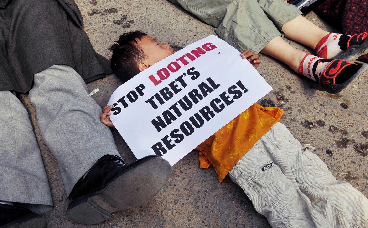 Young Tibetan boy protesting against China's looting of Tibet's natural resources