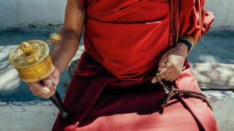 Tibetan monk with prayer wheel